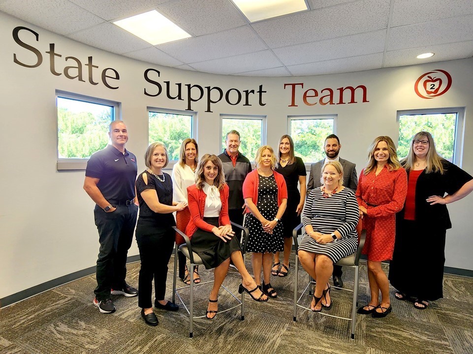 Group of people for staff photo wearing white, black, red